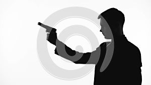 Silhouette of cold-blooded killer pointing handgun, revenge, contract killing