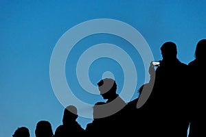 Silhouette of concert crowd and blue sky