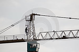 Silhouette of consruction worker on top of tower crane