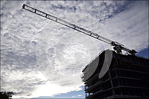 Silhouette of the construction crane in the construction site with blue sky