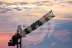 Silhouette construction crane, clouds, dusk