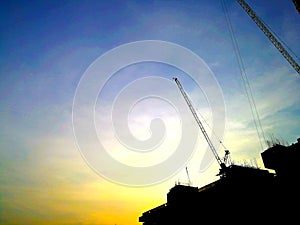 Silhouette Construction cranes machine against sky background.