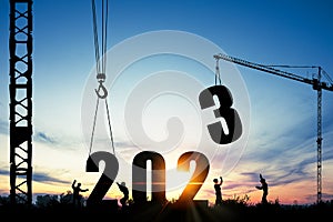 Silhouette of construction worker with crane and cloudy sky for preparation of welcome 2023 new year party and change new business