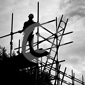 Silhouette construction worker on scaffolding building site