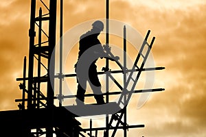 Silhouette construction worker on scaffolding building site photo