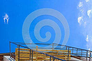 Silhouette of construction workers on scaffold working under a blue sky