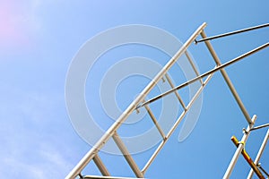 Silhouette of construction workers on scaffold working under a blue sky