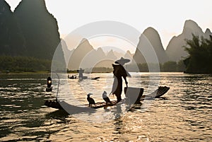Cormorant fishermen on bamboo rafts in river, China