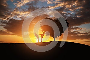 Silhouette of a couple in abstract field with heart shape tree with sunset.Romance and Valentine concept background.