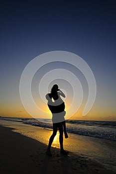 Silhouette of couple on beach at sunset