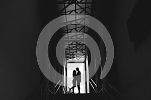 Silhouette of a couple on bright background at the end of an underground pedestrian tunnel