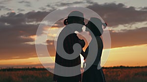 Silhouette of couple in golden sun and beautiful sunset. Young and romantic family enjoying. Man and woman in love on