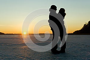 Silhouette of a couple hugging on ice