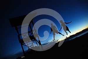 Silhouette of couple jumping in the air