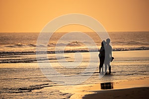 Silhouette of a couple kissing on a beach