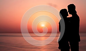 Silhouette of couple Kissing on the beach at Beautiful orange Sunrise