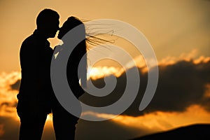 Silhouette of couple kissing at sunset