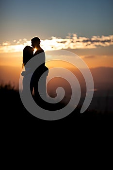 Silhouette of couple kissing in sunset