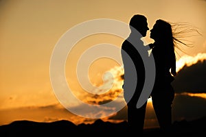 Silhouette of couple kissing at sunset