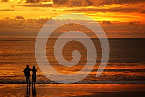silhouette of a couple looking at the sunset on a beautiful beach