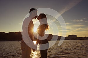 Silhouette of couple in love kissing and watching on the sunset