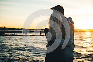 Silhouette of couple in love on the pier, sunset time, water bac