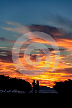 Silhouette of a couple at majestic cloduy sunset