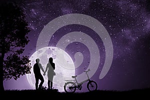Silhouette couple man and woman holding hand Full moon night With a Bicycle and birds that fly back to the nest.