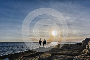 Silhouette of a couple standing at the ocean on sunset