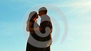 Silhouette of a couple at sunset. Man and woman silhouette in sunset slow motion. Couple in lifestyle love kissing at