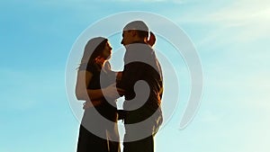 Silhouette of a couple at sunset. Man and woman silhouette in sunset slow motion. Couple in love kissing lifestyle at