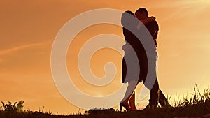 Silhouette of a couple at sunset. Man and woman silhouette in sunset slow motion. Couple in love kissing at lifestyle