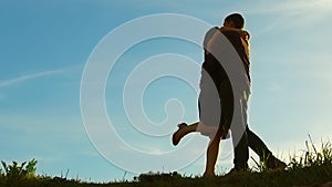 Silhouette of a couple at sunset. Man and woman silhouette in sunset slow motion. Couple in love kissing at sunrise