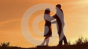 Silhouette of a couple at sunset. Man and woman silhouette in sunset slow motion. Couple in love kissing at sunrise. man
