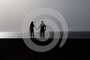 Silhouette of a couple at sunset over sea background. Love. Romantic. Holding hands