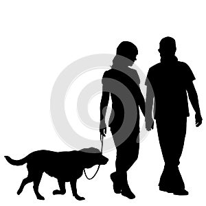 Silhouette of couple taking dog for walk