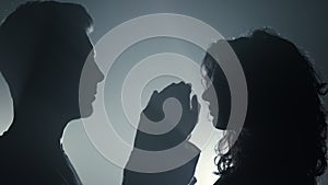 Silhouette couple touching each other indoors. Man woman with joined hands.