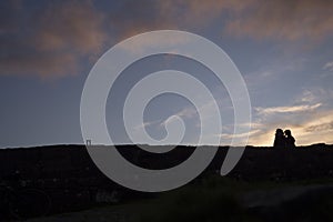 Silhouette of a couple of Unidentified gender against sunset sky. Copy space. Togetherness and closeness concept. Pair enjoys