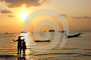 Silhouette couple used mobile selfie  on beach in sunset time,lover is celebrate in Valentine day by say love and propose.man and