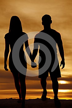 Silhouette couple walking hold hands