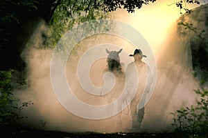 Silhouette of the cowboy and the horse in the morning sunrise