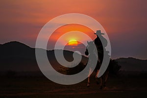 Silhouette of cowboy on horseback and sunset