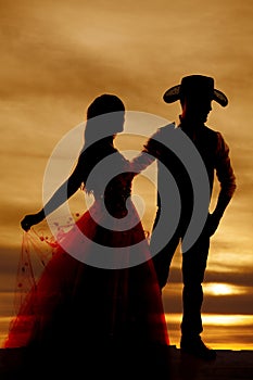 Silhouette cowboy and woman in dress photo