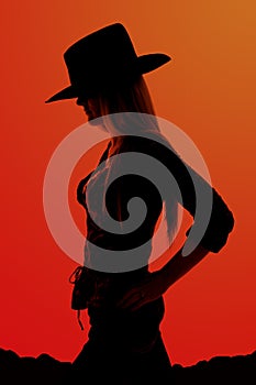 Silhouette of cowgirl with hands on her hips