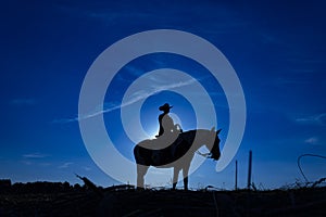 Silhouette cowgirl on horse at sunrise in blue 4