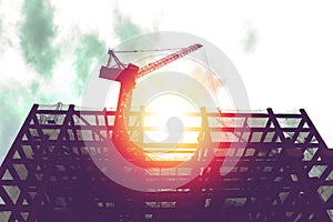 Silhouette of crane in building construction site