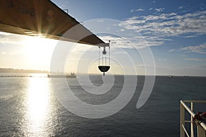 Silhouette of crane of the merchant cargo container vessel.