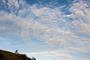 Silhouette of a cross country cyclist going downhill