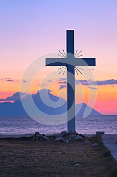 Silhouette of cross and mount Athos at sunrise or sunset with sea panorama