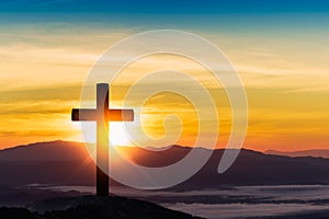 Silhouette of cross on mountain sunset background